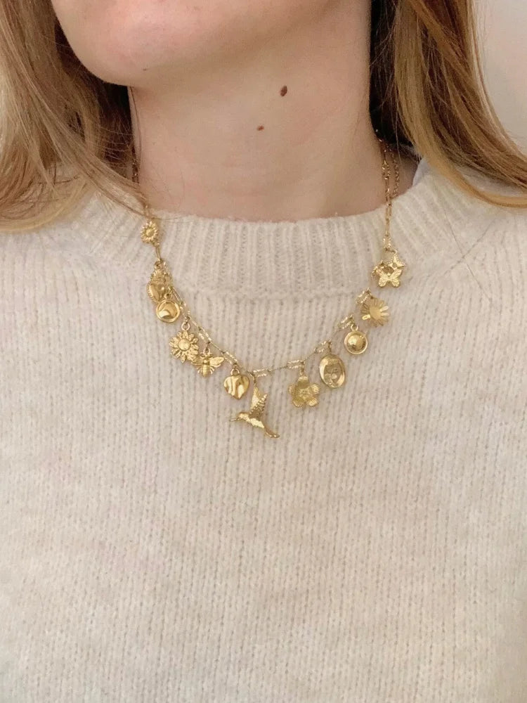 La femme porte le collier doré Lya en acier inoxydable de chez Au Bonheur de Sophie