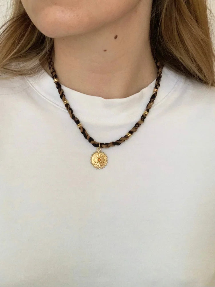 La femme porte le collier oeil doré en acier inoxydable de chez Au Bonheur de Sophie